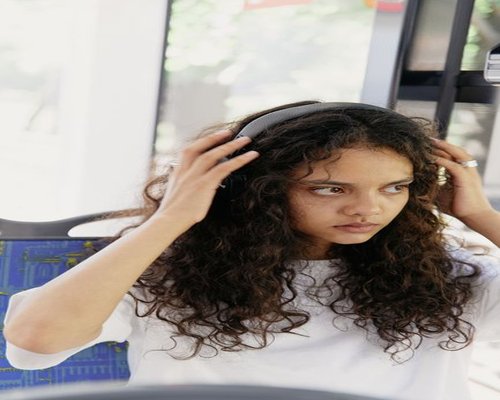 Person listening to headphones while commuting in a city bus