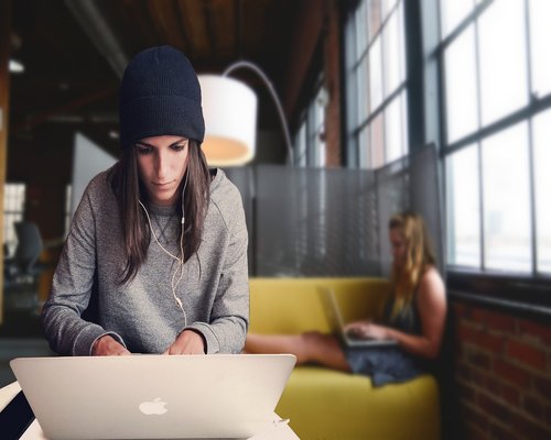 Students working on laptops in a spacious modern coworking space